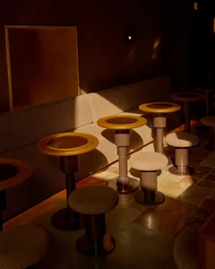 A cozy restaurant interior with multiple dining tables and chairs, creating an inviting atmosphere for socializing and meals