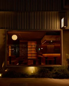 Warm and inviting restaurant interior with wooden tables and chairs, lit by interior lights