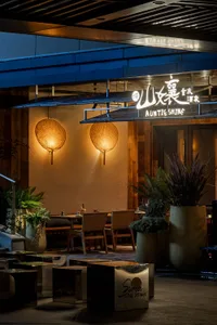 Cozy Asian restaurant with wooden interior, potted plants, and dim lighting