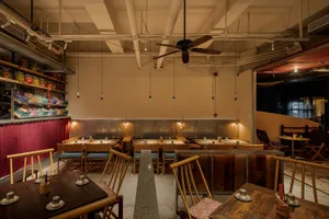 Modern restaurant interior with wooden tables and chairs, warm atmosphere, and ample seating options