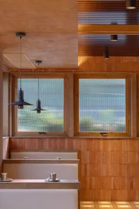 Bathroom with wooden walls, two sinks, and a window allowing natural light