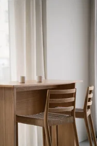 A cozy dining space with a wooden table and two chairs, featuring two cups and a warm atmosphere