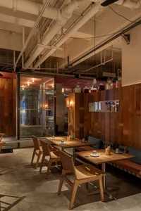Modern restaurant interior with wooden walls and tables, providing a warm and inviting atmosphere with ample seating options