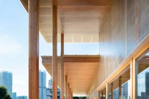 A rustic building with wooden pillars supporting a roof structure, featuring wooden beams and a traditional design
