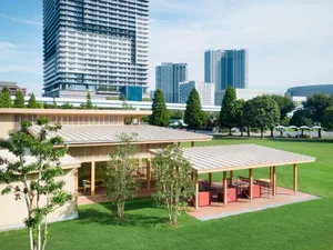 A wooden building surrounded by trees, featuring a seating area with multiple chairs, conveying a sense of relaxation and leisure