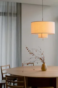 Cozy dining space with a wooden table, two chairs, and a vase with branches as a centerpiece