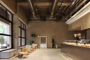 A modern restaurant with high ceilings, natural light, and comfortable seating areas with chairs and dining tables