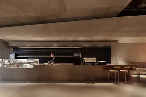 餐廳內部設有吧台與座椅，吧台上擺放各種物品，並有顧客在場