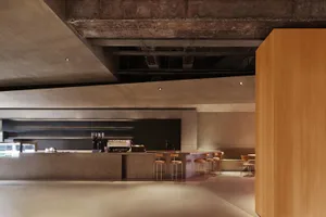 Inviting restaurant interior with a bar, dining area, and decorative bottles, featuring a warm and comfortable atmosphere
