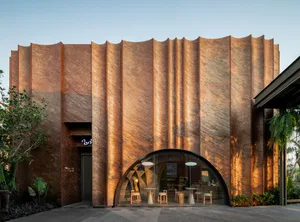 Inviting restaurant with an arched entrance, multiple dining tables, and comfortable seating