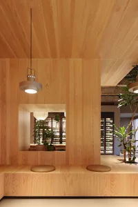 Warm and inviting interior design with wooden walls and ceilings, featuring potted plants and wine glasses in a comfortable and socializing area