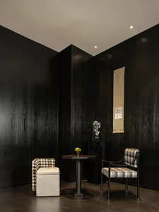 A cozy dining space with a black and white checkered chair and a vase, surrounded by chairs and a dining table