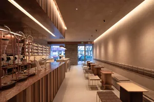 Inviting cafe with a bar and multiple dining tables, featuring comfortable seating and a social atmosphere