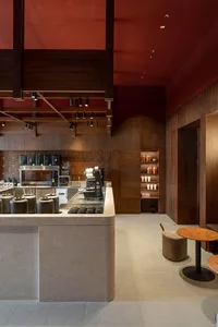 A cozy coffee shop interior with a counter featuring cups, bottles, and bowls, creating an inviting atmosphere for customers