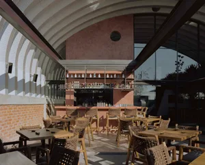 A cozy bar area with a counter and chairs, surrounded by bottles and an inviting atmosphere