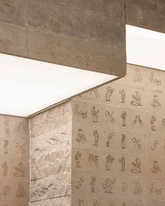 Ancient stone wall covered in intricate hieroglyphics, creating a complex and textured pattern