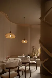 A dining area with a long table and multiple chairs, set with various items, creating an inviting atmosphere for guests