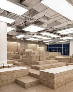 A spacious outdoor area with stone steps, benches, and stone tile flooring, featuring a dimly lit and cozy ambiance