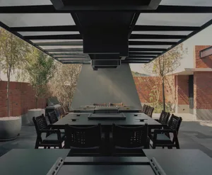 A modern dining area with a large wooden table surrounded by black chairs, creating a comfortable and inviting atmosphere