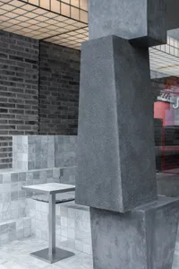 A dimly lit restaurant with brick walls, tables, and chairs, creating a cozy atmosphere