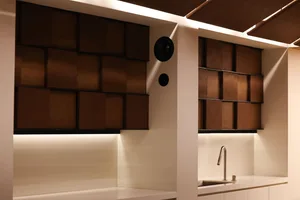 Kitchen with white cabinets, brown wooden walls, and a marble countertop, giving off a clean and modern vibe