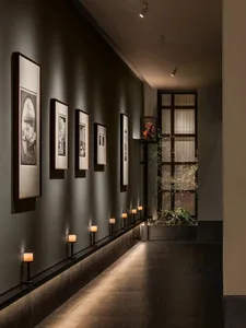 A dimly lit hallway with several pictures hanging on the wall, creating a dark and mysterious atmosphere