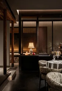 Sophisticated dining space with wooden tables and chairs, wine glasses, and a warm atmosphere