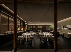 Elegant restaurant interior with multiple tables, chairs, and decorative items, creating a sophisticated atmosphere for upscale dining