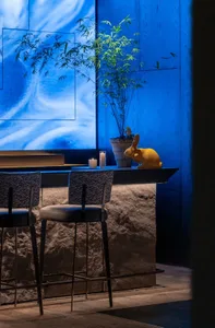 Dining area with a wooden table surrounded by chairs, a vase, and a TV on the wall, creating a warm and inviting atmosphere