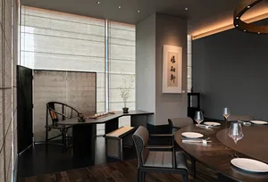 精緻餐廳區域，配有大餐桌、椅子與酒杯，周圍環繞現代設計元素與極簡裝飾