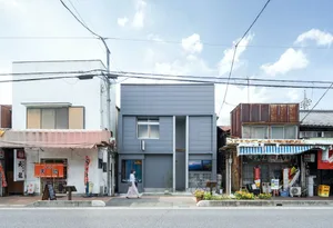 兩棟相鄰的建築，一現代一傳統，設有窗戶、門戶與戶外座位區，位於城市環境中