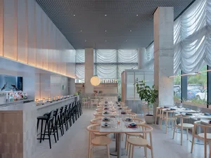 Empty modern restaurant interior with a large dining table, potted plants, and concrete walls, featuring warm lighting
