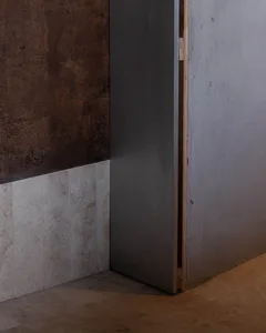 A modern interior space with a steel door and a brown wall with a tiled surface