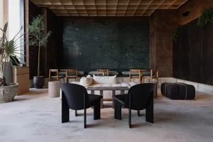 A modern showroom with a large black table surrounded by multiple chairs, well-lit for a comfortable atmosphere