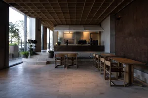 A dining area with a wooden table surrounded by chairs and potted plants, creating a warm and inviting atmosphere