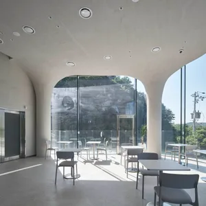A modern restaurant interior with multiple dining tables and chairs, well-lit for a comfortable atmosphere