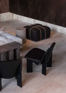 A modern showroom featuring black furniture, including chairs, couches, and dining tables, in a well-lit and stylish setting