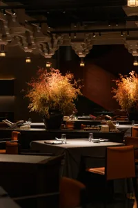Elegant dining space with modern chairs, vases of flowers, and a sophisticated ambiance