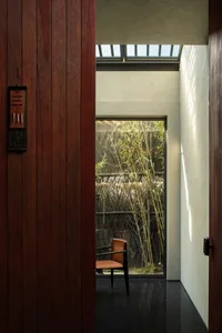 Cozy room with wooden walls and floors, featuring two chairs and a potted plant, creating a warm atmosphere