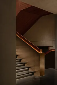 A two-flight staircase with wooden steps and brown color, set in an elegant and inviting atmosphere