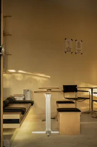 Empty minimalist room with a wooden floor and walls, featuring chairs and a dining table