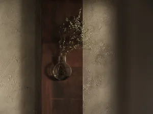 A wooden wall with a vase containing flowers hanging on it, adding a touch of nature to the space