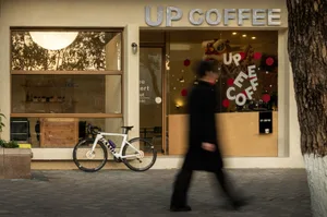 A casual coffee shop with comfortable seating, bicycles parked outside, and a welcoming atmosphere