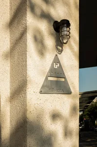 A building with a metal triangle sign and a brick exterior, conveying a sense of urban architecture and functionality