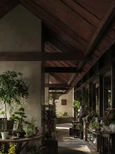 A warm and inviting indoor space with a dining area, potted plants, and decorative vases, surrounded by a lush green environment