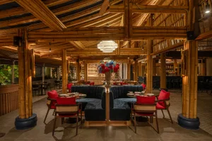 A warm and inviting restaurant interior with wooden elements, bamboo ceiling, multiple dining tables, and chairs