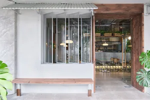 Casual restaurant bar area with dining tables, chairs, and backpacks, set in a relaxed atmosphere