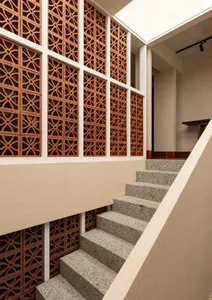 A well-crafted staircase with stone steps leading to a second floor, set against a neutral background