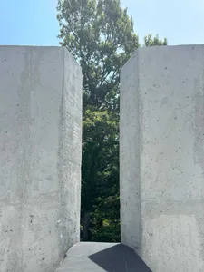 A minimalist architectural scene featuring two large concrete pillars as part of a building's facade, with a focus on structural aspects