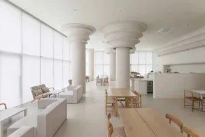 Inviting restaurant space with high ceilings, columns, and dining areas with chairs and tables